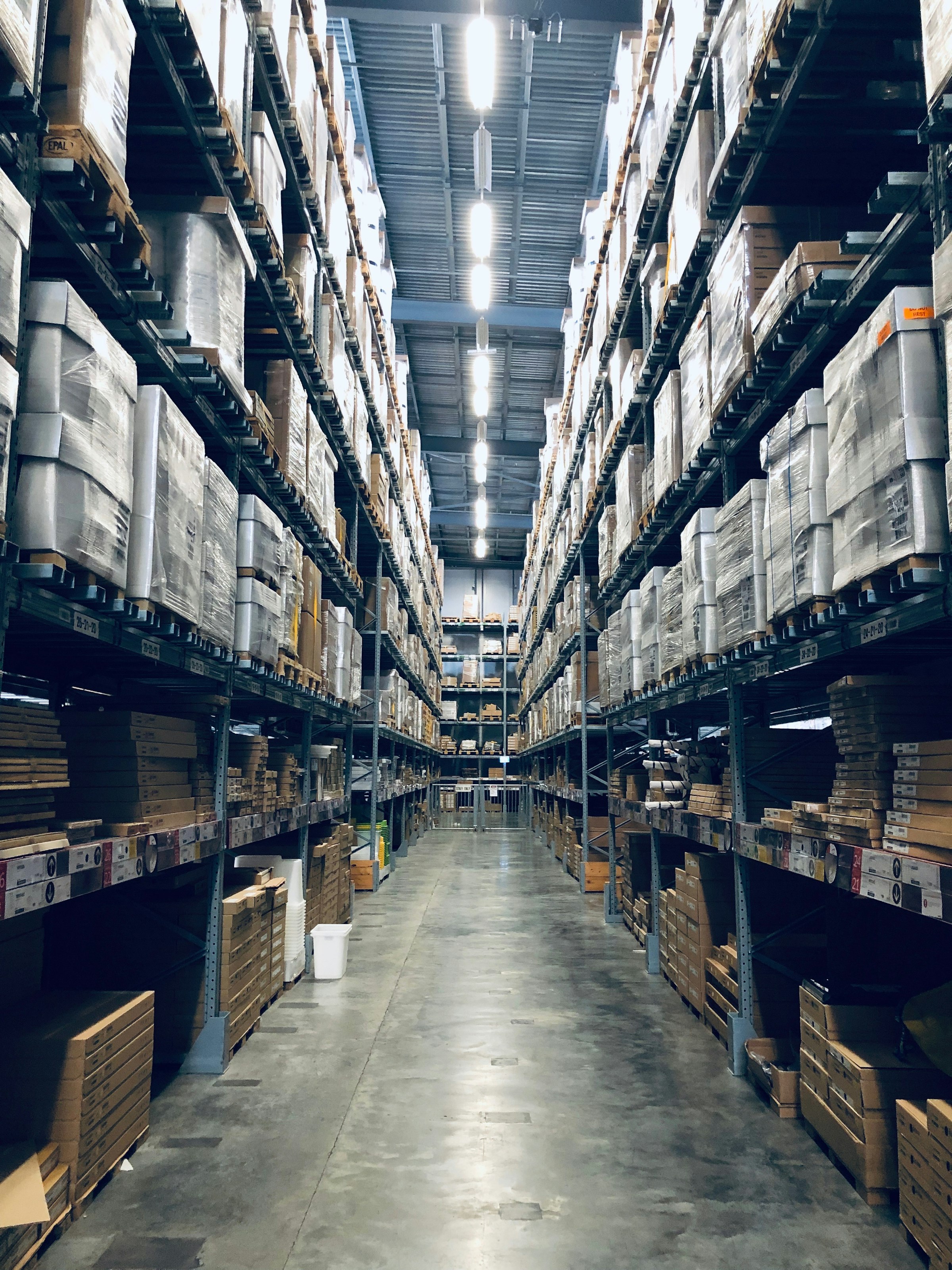 High-bay warehouse aisle stacked with palletised inventory