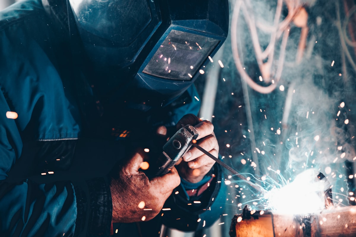 Welder working with industrial equipment